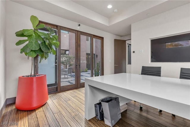 office area featuring french doors, a tray ceiling, and hardwood / wood-style floors