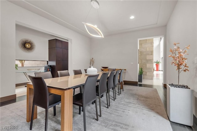 dining space with a notable chandelier and light hardwood / wood-style flooring