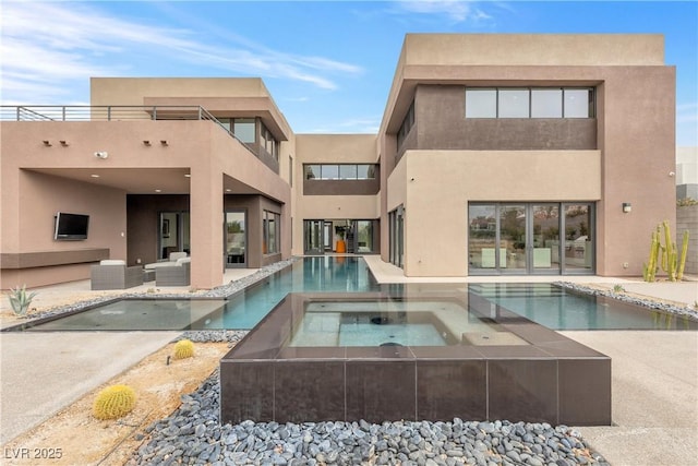 back of property featuring a pool with hot tub, an outdoor living space, and a patio