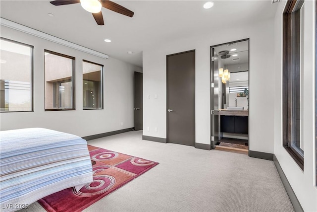 bedroom featuring ensuite bathroom and light colored carpet