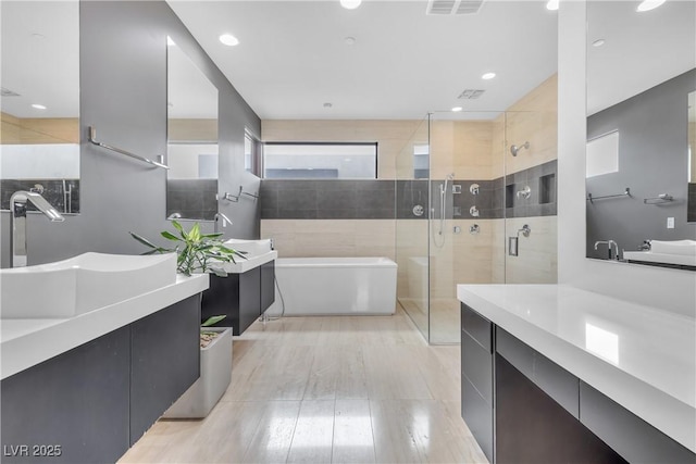 bathroom featuring vanity and separate shower and tub