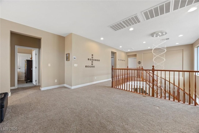 unfurnished room with carpet and a chandelier