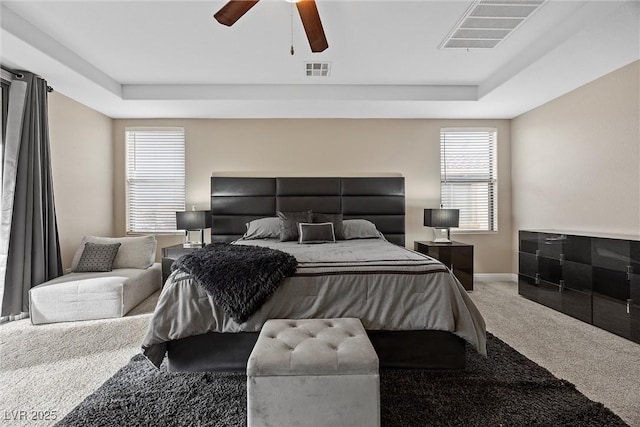 bedroom featuring a tray ceiling, ceiling fan, and carpet