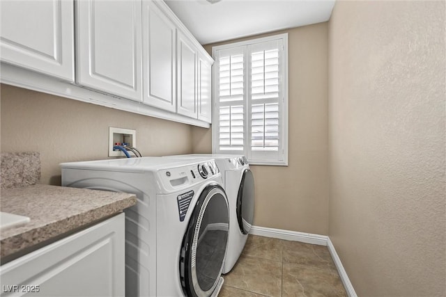 laundry room with independent washer and dryer, light tile patterned floors, and cabinets