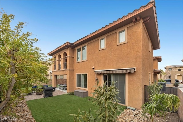 back of property with a patio and a lawn