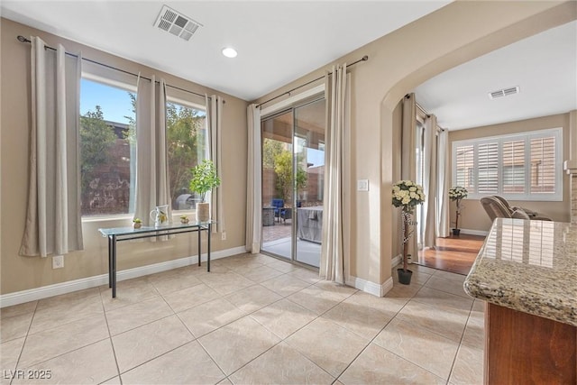 doorway featuring a healthy amount of sunlight and light tile patterned floors