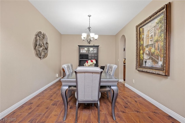 dining room featuring a notable chandelier and dark wood-type flooring