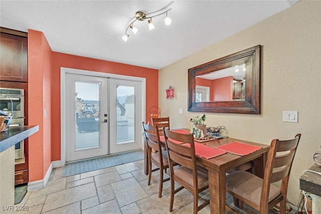 dining space featuring french doors and a textured ceiling