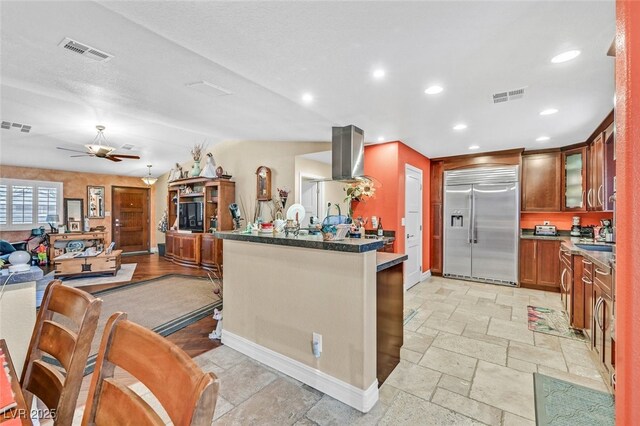 kitchen featuring stainless steel built in refrigerator, sink, island range hood, and ceiling fan