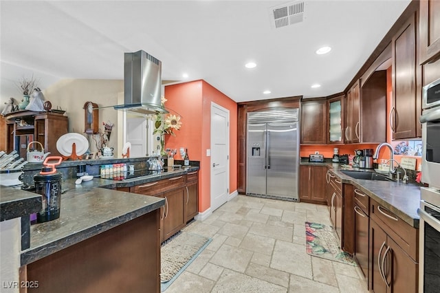 kitchen featuring sink, wall oven, island exhaust hood, black electric cooktop, and stainless steel built in fridge