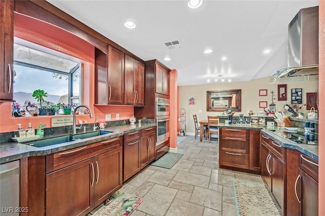 kitchen featuring wall chimney exhaust hood, stainless steel appliances, and sink