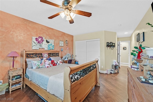 bedroom featuring dark hardwood / wood-style floors, ceiling fan, and a closet