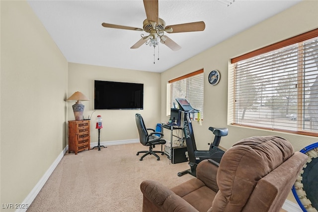 carpeted office space featuring ceiling fan