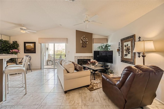 tiled living room featuring ceiling fan and lofted ceiling