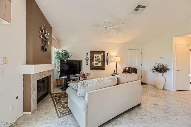 living room featuring light tile patterned flooring, ceiling fan, and a premium fireplace