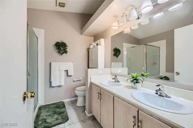 bathroom featuring tile patterned flooring, vanity, a shower with door, and toilet