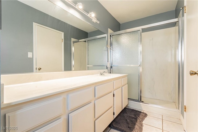 bathroom with tile patterned flooring, vanity, and a shower with door