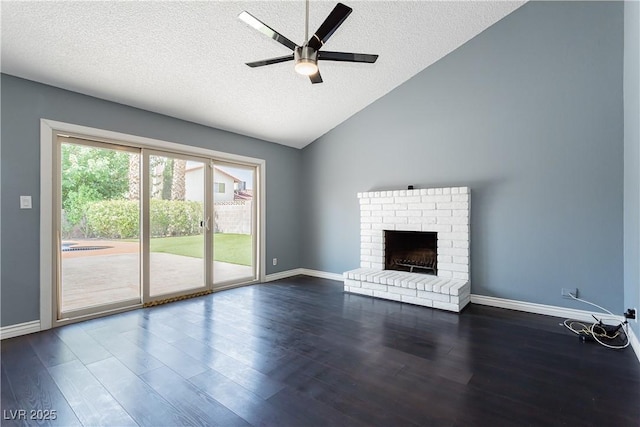 unfurnished living room with vaulted ceiling, dark wood-type flooring, a textured ceiling, and a fireplace