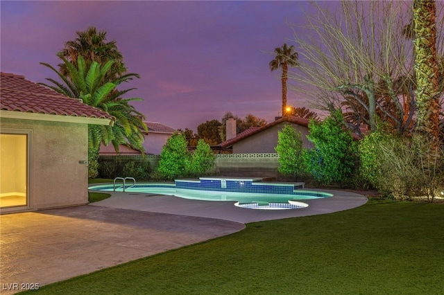 pool at dusk with a yard and a patio