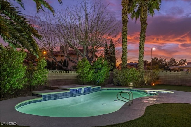 pool at dusk featuring a patio area