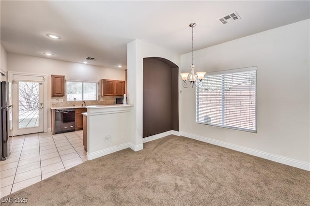 kitchen with black appliances, a notable chandelier, pendant lighting, light colored carpet, and backsplash