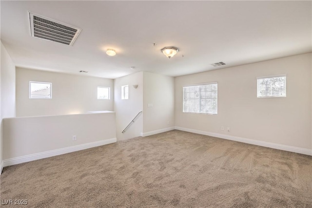 empty room with a healthy amount of sunlight and carpet