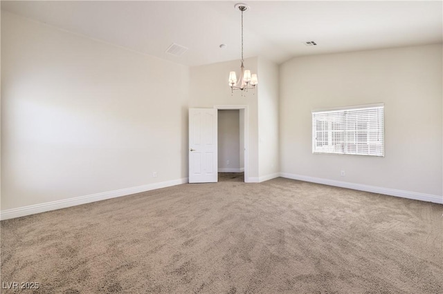 spare room with an inviting chandelier, carpet flooring, and vaulted ceiling