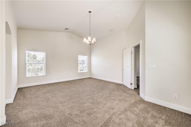 empty room featuring vaulted ceiling, carpet floors, and an inviting chandelier