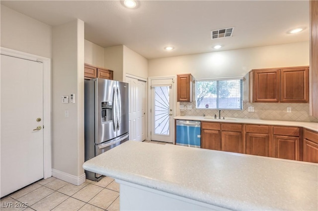 kitchen featuring tasteful backsplash, appliances with stainless steel finishes, sink, and light tile patterned floors