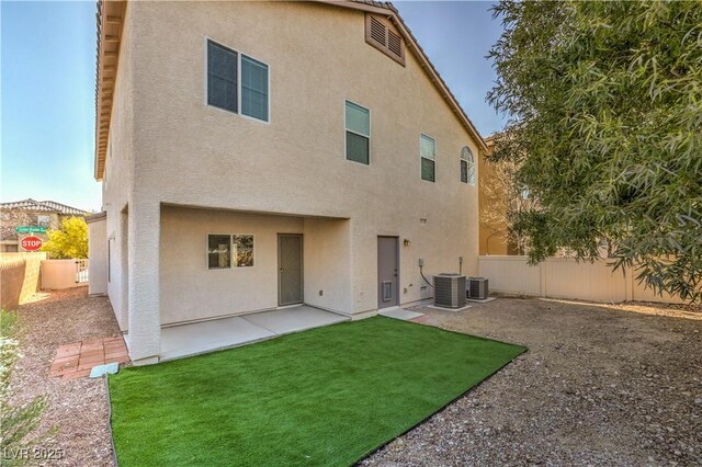 rear view of property with central AC unit, a lawn, and a patio