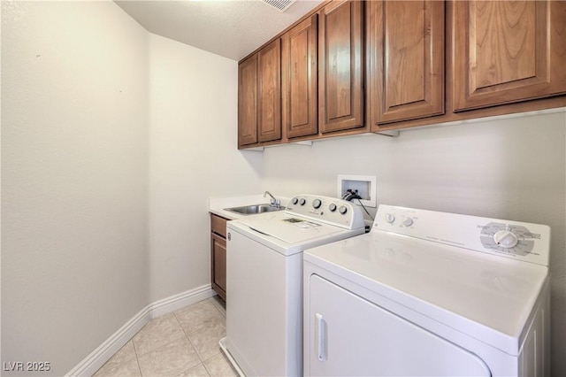 washroom with separate washer and dryer, sink, cabinets, and light tile patterned flooring