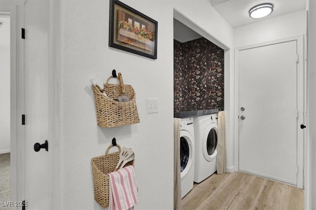 washroom with washing machine and clothes dryer and light wood-type flooring