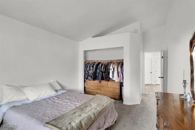 carpeted bedroom featuring vaulted ceiling and a closet