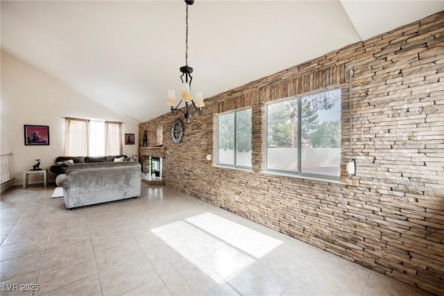 unfurnished living room featuring light tile patterned flooring, high vaulted ceiling, a notable chandelier, and a fireplace