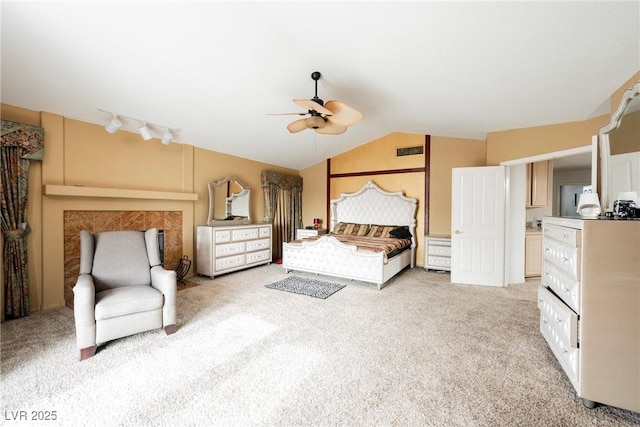 unfurnished bedroom with vaulted ceiling, light carpet, track lighting, and ceiling fan