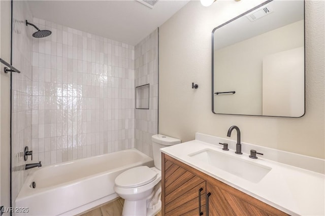 full bathroom featuring tiled shower / bath, vanity, and toilet