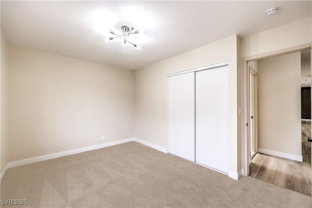 unfurnished bedroom with a closet and light carpet