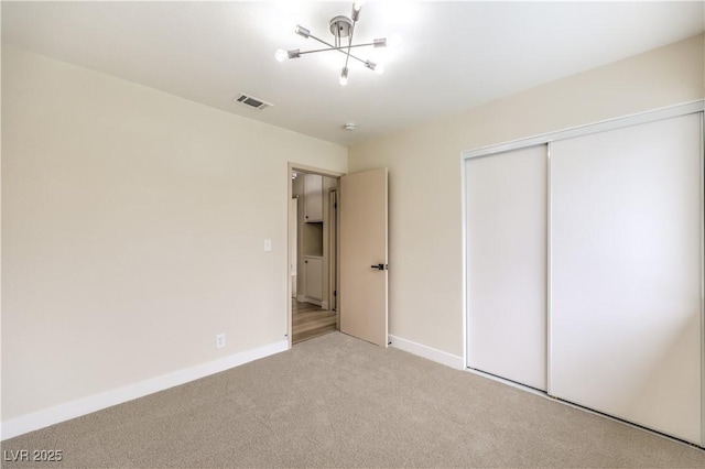 unfurnished bedroom with light carpet and a closet