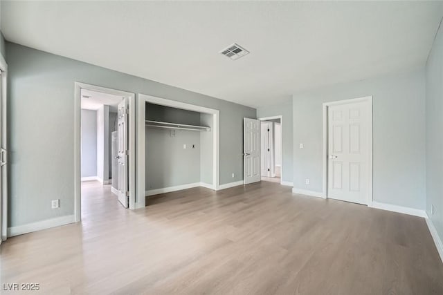 unfurnished bedroom with light wood-type flooring and a closet