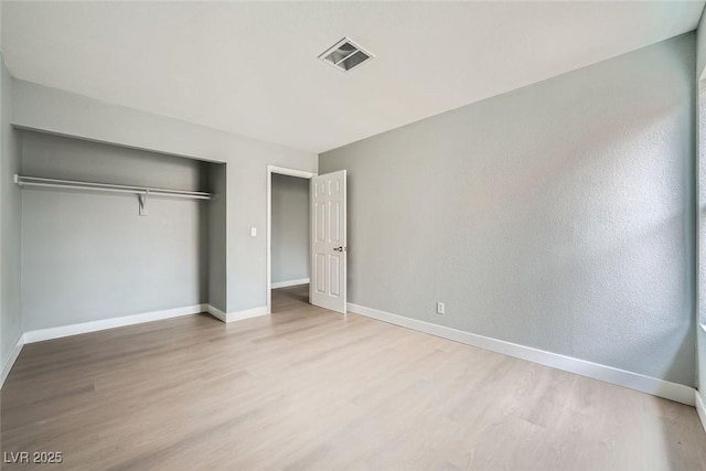 unfurnished bedroom featuring light hardwood / wood-style flooring and a closet