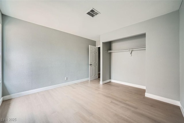 unfurnished bedroom featuring hardwood / wood-style floors and a closet