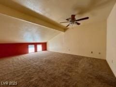 bonus room with lofted ceiling with beams, carpet, and ceiling fan