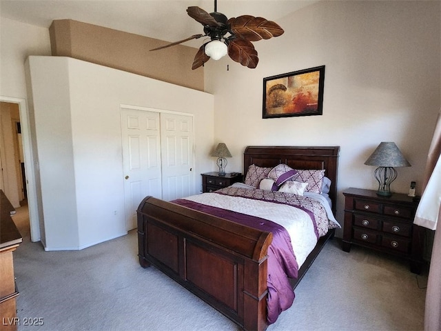 carpeted bedroom with a towering ceiling, a closet, and ceiling fan