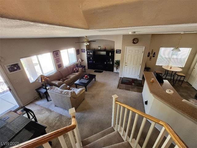 living room featuring vaulted ceiling, carpet flooring, and ceiling fan