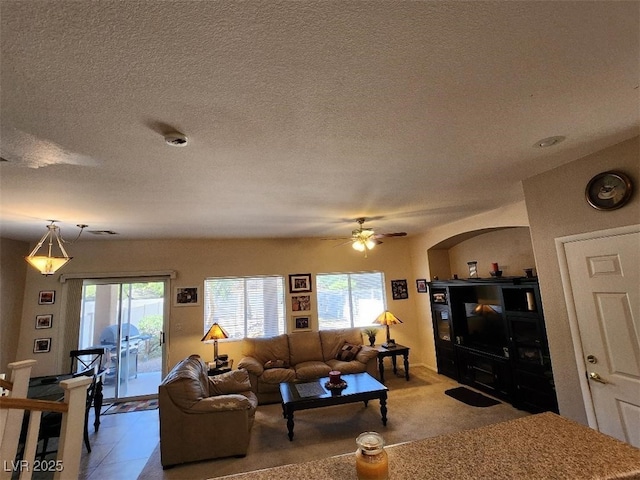 living room featuring ceiling fan and a textured ceiling