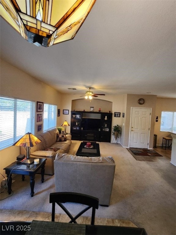 carpeted living room with ceiling fan