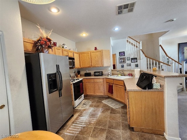 kitchen with stainless steel fridge with ice dispenser, sink, light brown cabinets, kitchen peninsula, and white gas stove