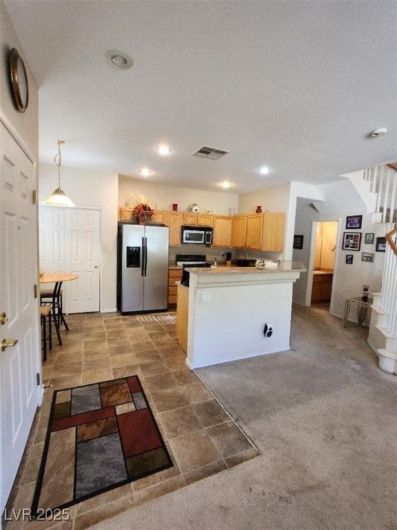 kitchen featuring a kitchen island, appliances with stainless steel finishes, decorative light fixtures, light carpet, and light brown cabinets