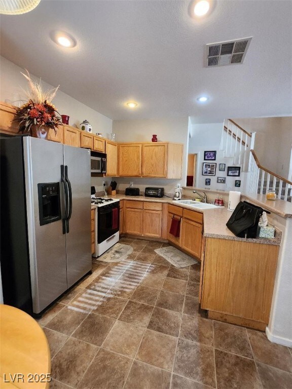 kitchen with stainless steel appliances, sink, and kitchen peninsula