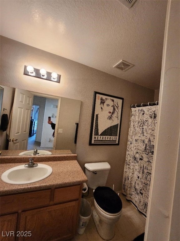 bathroom with vanity, toilet, a shower with shower curtain, and a textured ceiling